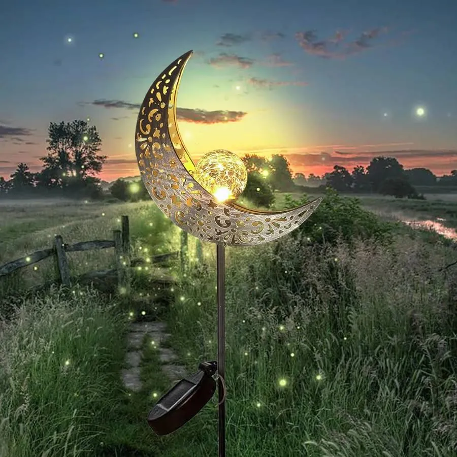 Solar moon stake light glowing in a border